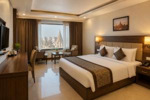 a hotel room with a large bed and a desk at Mayott By Vilaastaa in Indore