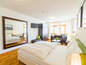 a white bedroom with a bed and a living room at The Square Coburg in Coburg +15 photos