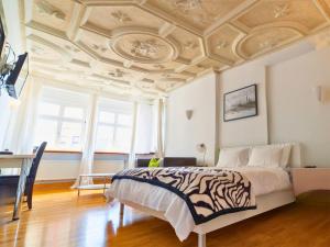 a bedroom with a bed and a coffered ceiling at The Square Coburg in Coburg