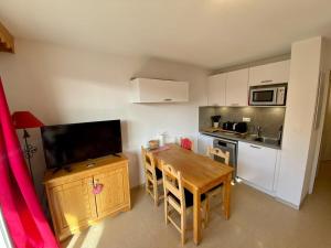 a small kitchen with a wooden table and a kitchenette with a dining room at T2 view, skiing, summer pool Balcons du Soleil in Allos