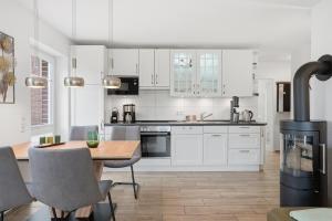 a kitchen with white cabinets and a table and a stove at Grachtenblick I in Greetsiel