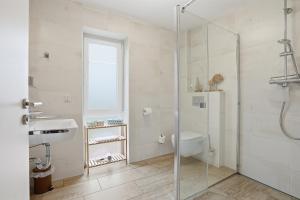 a bathroom with a shower and a sink and a toilet at Grachtenblick I in Greetsiel +20 photos
