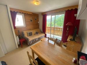 a room with a bed and a table and a window at T2 view, skiing, summer pool Balcons du Soleil in Allos