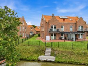 a house with a dock in front of a body of water at Grachtenblick I in Greetsiel