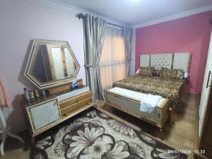 a bedroom with a bed and a mirror and a rug at عمارة 14 in Madīnat ash Shurūq