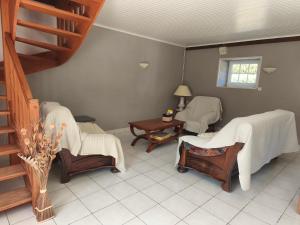 a room with massage chairs and a table and stairs at Gîte Mouchel in Le Vrétot