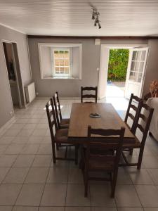 a dining room with a wooden table and chairs at Gîte Mouchel in Le Vrétot