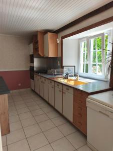 a large kitchen with a sink and a window at Gîte Mouchel in Le Vrétot