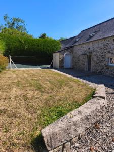 a stone house with a yard and a driveway at Gîte Mouchel in Le Vrétot