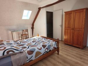 a bedroom with a bed and a wooden cabinet at Gîte Mouchel in Le Vrétot +2 photos