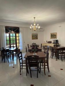 a dining room with tables and chairs and a chandelier at Villa Bice in Pulsano