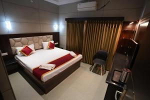 a bedroom with a large bed and a chair at KAR Towers in Ārani