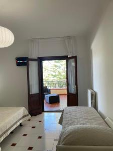 a bedroom with two beds and a door to a patio at Villa Bice in Pulsano