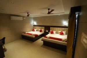 a bedroom with two beds and a ceiling fan at KAR Towers in Ārani
