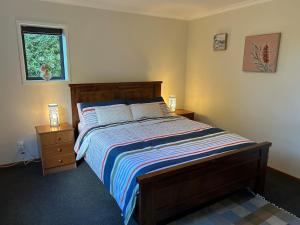 a bedroom with a bed with two night stands and a window at Spacious peaceful apartment in Wellington