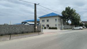 a white house with a blue roof on a street at Senera Minerals in Valea lui Mihai