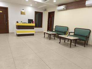 a waiting room with two chairs and tables and a counter at Hotel Sunshine Apartment in Bathinda