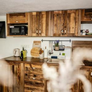 a kitchen with wooden cabinets and a sink at Chata na samote in Revúca +2 photos