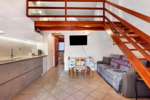 a living room with a couch and a kitchen at Bilo Lu Impostu in Nuragheddu