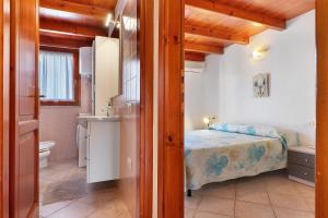 a small bedroom with a bed and a bathroom at Bilo Lu Impostu in Nuragheddu