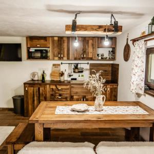 a kitchen with a wooden table in a room at Chata na samote in Revúca