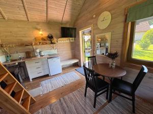 a kitchen with a table and chairs in a cabin at Laasi Cozy Cottage in Kaigutsi