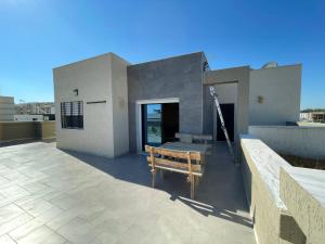 a building with a bench on a patio at DarNejib, El Wafa City, Hammamet-Nabeul in Nabeul