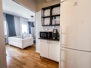 a kitchen with a refrigerator and a living room at Nässjö Vandrarhem in Nässjö