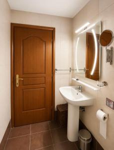 a bathroom with a sink and a wooden door at Archontiko Tsikari in Város +34 photos