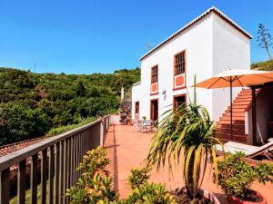a balcony of a house with an umbrella at Neólida in Puntallana