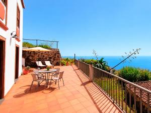 a balcony with a table and chairs and the ocean at Neólida in Puntallana