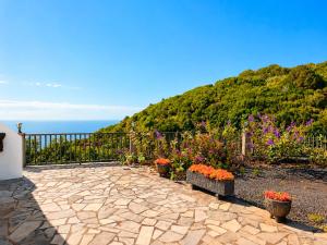 a patio with flowers and a fence and the ocean at Neólida in Puntallana