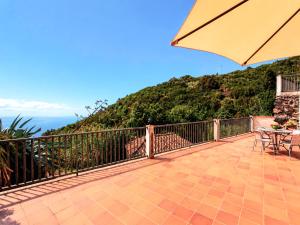 a balcony with a table and an umbrella at Neólida in Puntallana +20 photos