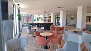 a restaurant with tables and chairs and a bar at WE Hotel EXPO Prague in Prague