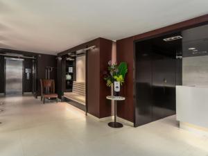 a lobby with a vase of flowers on a table at rock sidecoast in Quismondo
