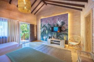a bedroom with a bed and a tv on a wall at Villa Lukka in Cıralı