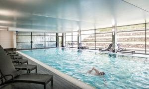 a woman laying in a swimming pool in a building at Norton House Hotel & Spa, Edinburgh in Ingliston