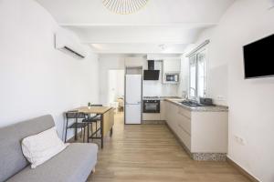 a kitchen and living room with a couch and a table at Casa Socra in Arcos de la Frontera