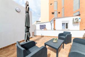 a patio with chairs and an umbrella and a table at Casa Maruchi Apartamento 2 in Almería