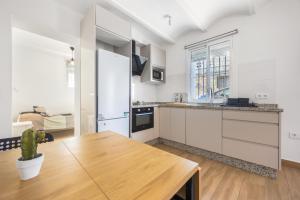 a kitchen with white cabinets and a wooden table at Casa Socra in Arcos de la Frontera +13 photos