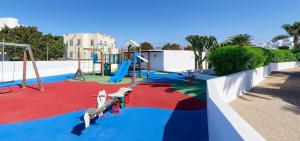 a playground with a slide and a swing set at Hotel Floresta in Puerto del Carmen