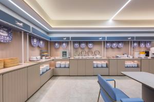 a restaurant with counters and tables and blue chairs at Hanting Hotel Beijing Xizhimen in Beijing