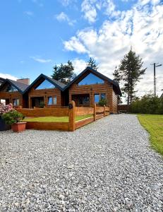 a house with a wooden fence in front of it at Pod Bieszczadzkim Niebem in Lutowiska