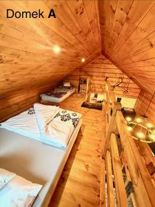 a bedroom with two beds in a wooden room at Pod Bieszczadzkim Niebem in Lutowiska +97 photos