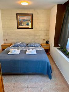 a bedroom with a blue bed with towels on it at Villa GoldenPearl in Povile