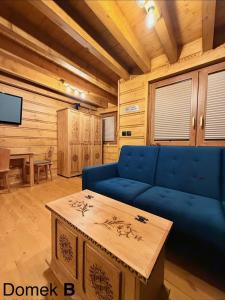 a living room with a blue couch and a table at Pod Bieszczadzkim Niebem in Lutowiska