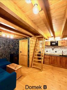 a living room with a blue couch and a kitchen at Pod Bieszczadzkim Niebem in Lutowiska