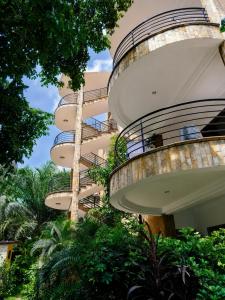 a building with a spiral staircase in front of trees at Luxor Gardens Residences in Accra
