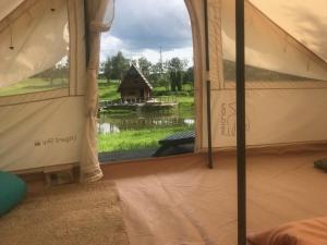 a bedroom with a view of a house from a tent at GLaMPLIFE,tünni ja suitsusaunaga in Kasaritsa