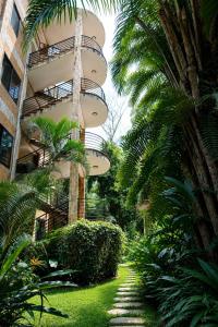 a building with a balcony and palm trees next to a walkway at Luxor Gardens Residences in Accra